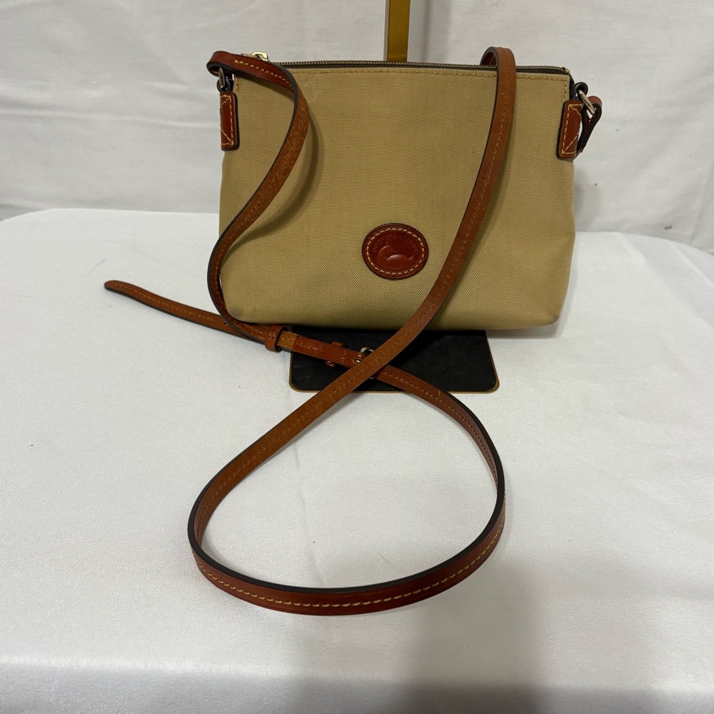 Dooney & Bourke Nylon Crossbody Pouchette bag in a tan with leather trim.